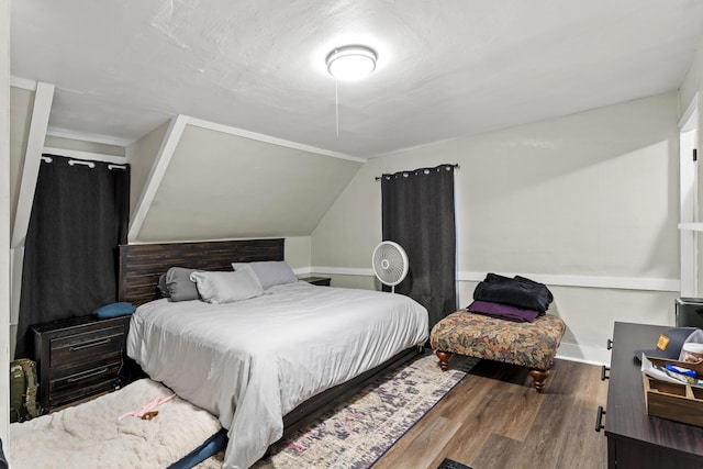 bedroom featuring vaulted ceiling, baseboards, and wood finished floors