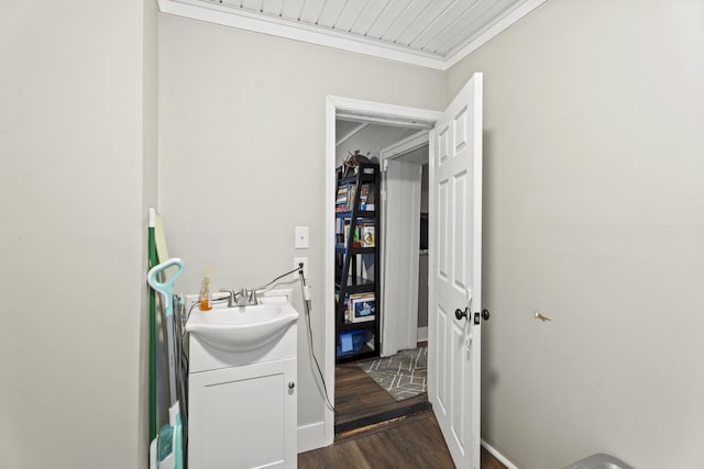 laundry area with dark wood-style flooring, a sink, and crown molding