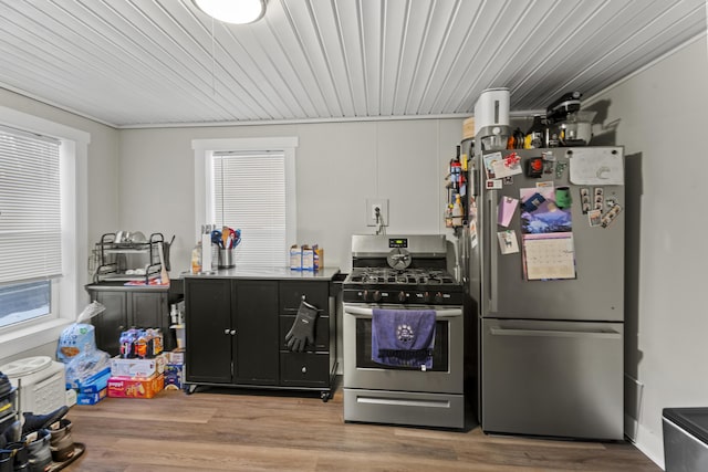 kitchen with appliances with stainless steel finishes, light wood-style floors, a wealth of natural light, and white cabinets