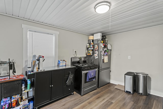 kitchen featuring dark cabinets, stainless steel appliances, dark wood-style flooring, baseboards, and light countertops