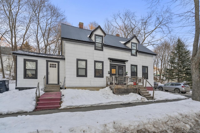 view of front of house featuring a chimney and metal roof