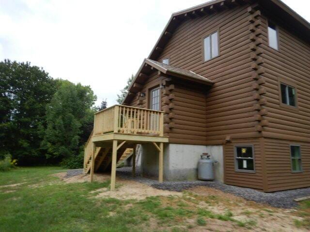 back of house with stairs, log siding, and a wooden deck