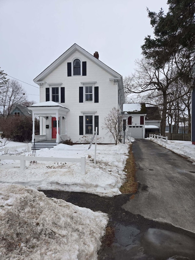 view of front of home with a chimney and an outbuilding