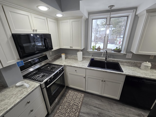 kitchen featuring dark wood-style flooring, decorative light fixtures, black appliances, white cabinetry, and a sink