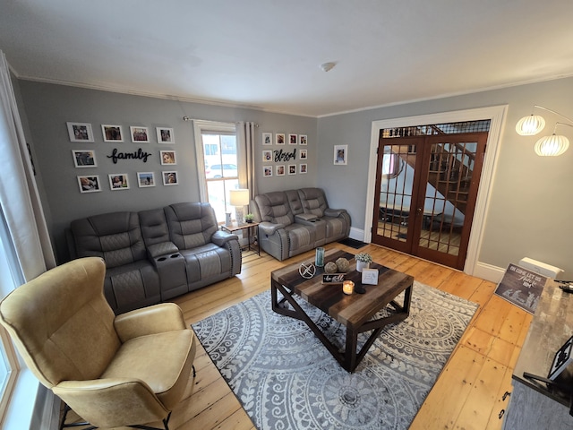 living area with french doors, baseboards, crown molding, and light wood finished floors