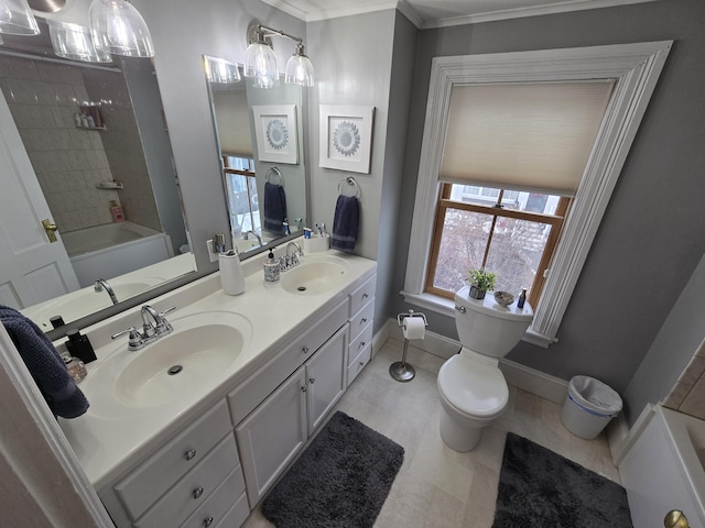 bathroom with double vanity, a sink, toilet, and baseboards