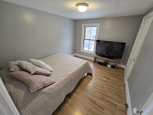 bedroom featuring baseboards and wood finished floors