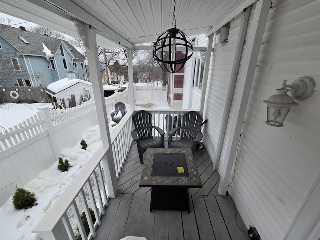 snow covered deck with a residential view and fence