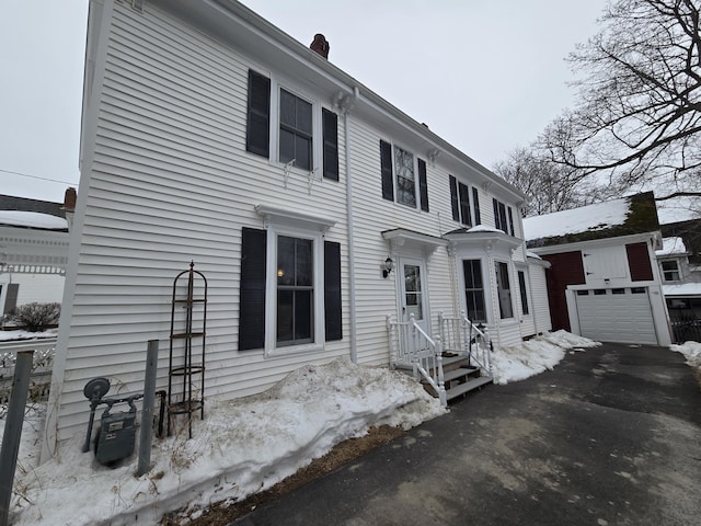 view of front facade featuring a garage and an outdoor structure