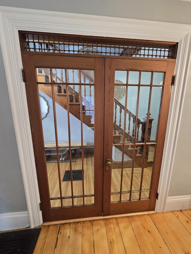 doorway to outside with french doors, wood-type flooring, and baseboards