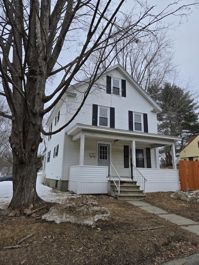 american foursquare style home with a porch and fence