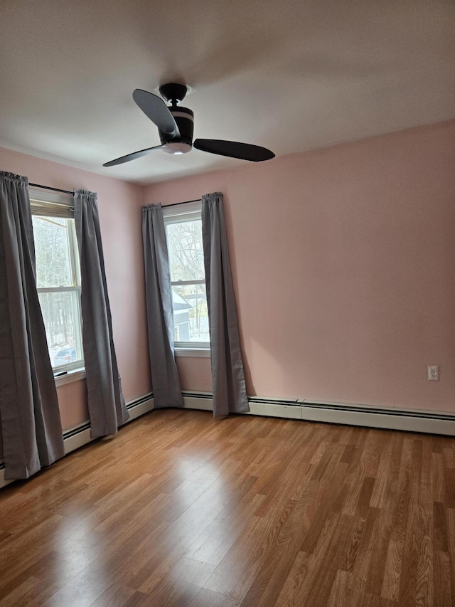 empty room featuring a wealth of natural light, ceiling fan, and wood finished floors