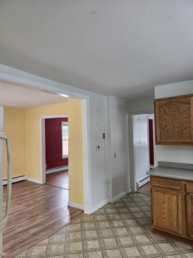 interior space with light floors, baseboards, and a baseboard heating unit