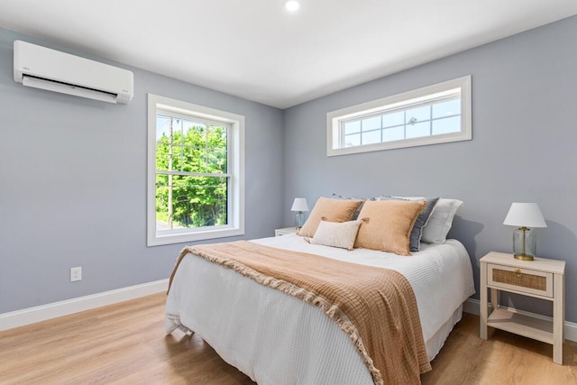 7 Parsonage Rd Unit 5, North Yarmouth, ME 04097 - bedroom with a wall unit AC, light wood-type flooring, multiple windows, and baseboards