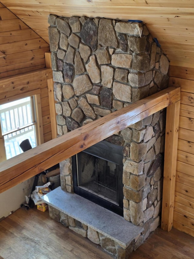 details featuring wooden ceiling, a fireplace, wooden walls, and wood finished floors