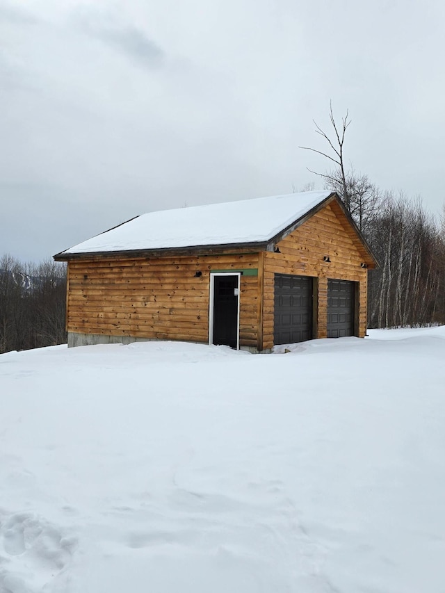 snow covered garage with a garage