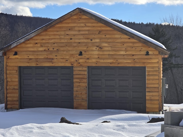 snow covered garage with a garage