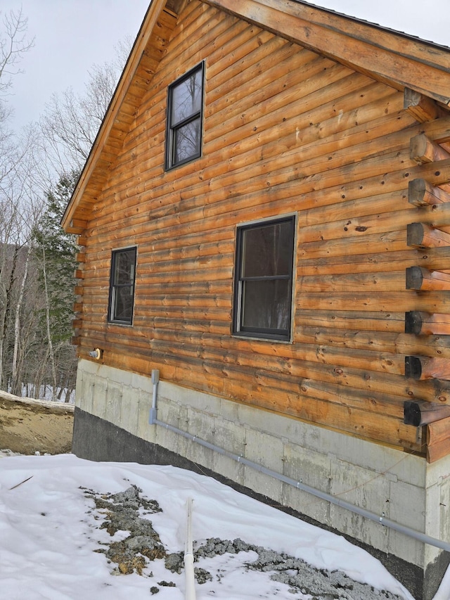 view of snow covered exterior featuring log exterior