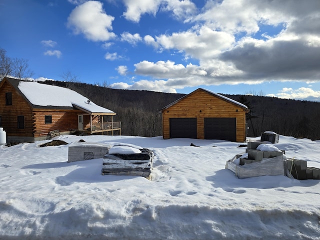 view of front facade with a detached garage and an outbuilding