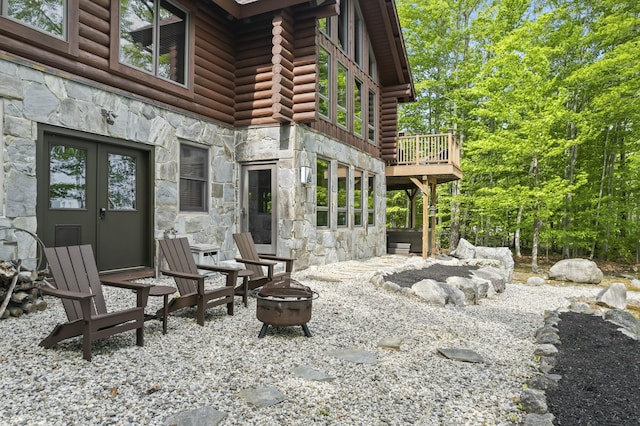 view of patio / terrace featuring a fire pit, a deck, and french doors