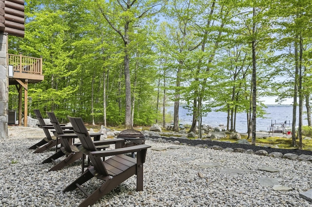 view of community featuring an outdoor fire pit and a water view