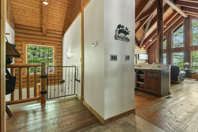 corridor with dark wood-type flooring, wood ceiling, high vaulted ceiling, beamed ceiling, and baseboards