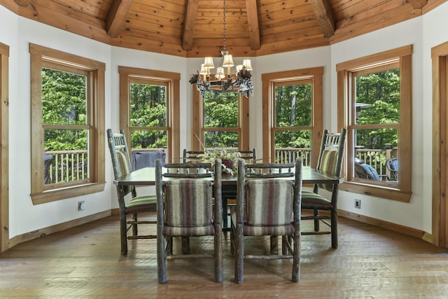 dining space featuring a chandelier, baseboards, a wealth of natural light, and vaulted ceiling with beams