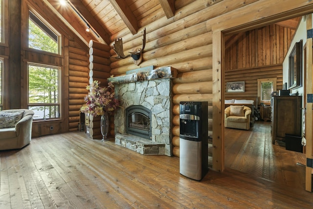 unfurnished living room featuring wood ceiling, a stone fireplace, high vaulted ceiling, beamed ceiling, and hardwood / wood-style flooring