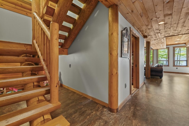 stairway featuring wooden ceiling and baseboards