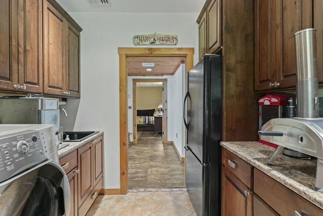 clothes washing area with laundry area, visible vents, light tile patterned floors, and washer / clothes dryer