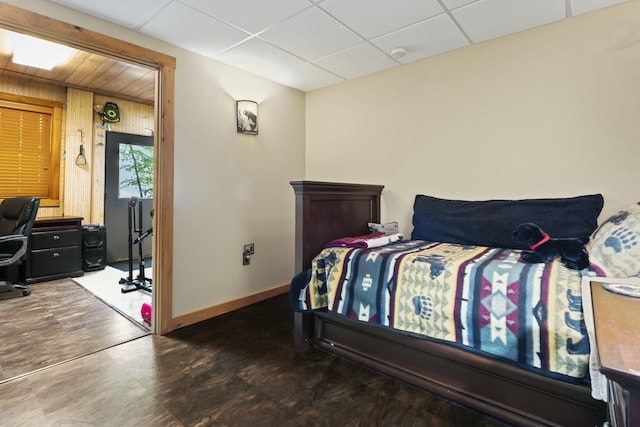 bedroom featuring a paneled ceiling and baseboards