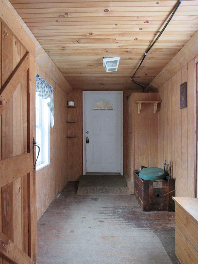 interior space with wood walls, wooden ceiling, and wood finished floors