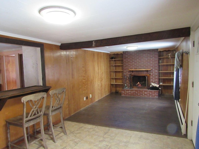 finished basement featuring built in shelves, a brick fireplace, wooden walls, and tile patterned floors