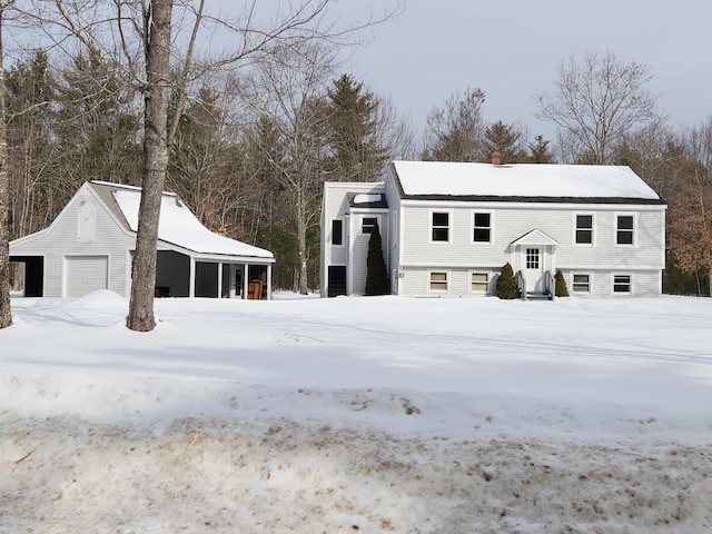 view of front facade with a detached garage and a chimney