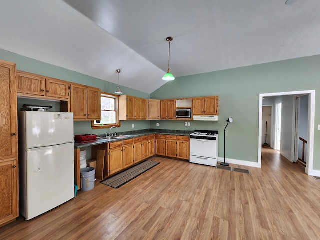 kitchen featuring decorative light fixtures, dark countertops, a sink, white appliances, and under cabinet range hood