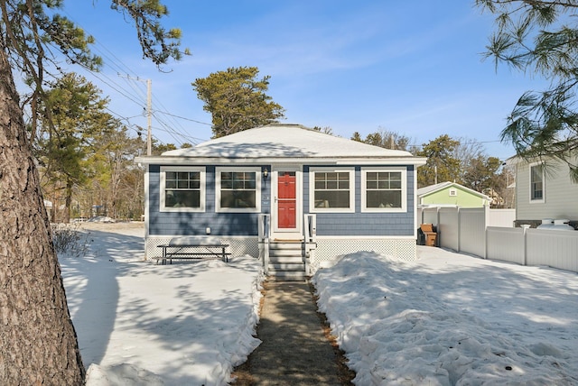 bungalow-style home featuring fence and a detached garage