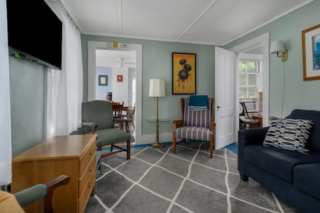 living area with ornamental molding, carpet, and baseboards