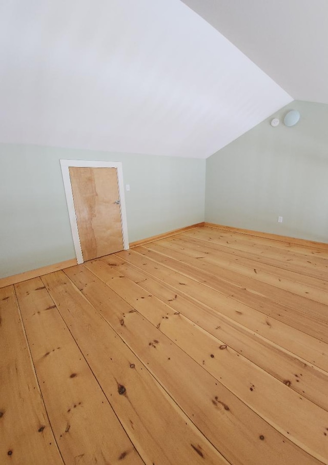 bonus room featuring lofted ceiling and light wood-style flooring