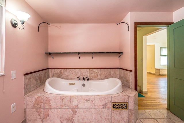 bathroom with tile patterned flooring and a bath