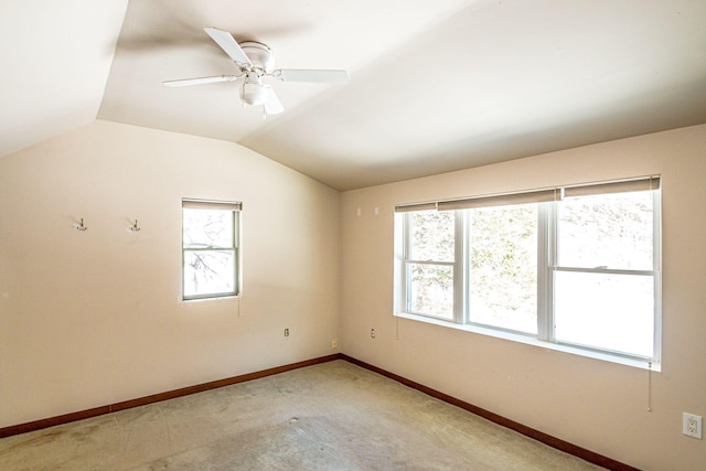 empty room featuring lofted ceiling, light carpet, ceiling fan, and baseboards