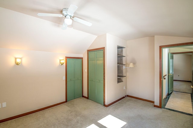 unfurnished bedroom featuring vaulted ceiling, light carpet, a ceiling fan, and baseboards