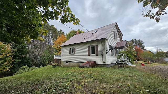 view of property exterior with metal roof and a yard