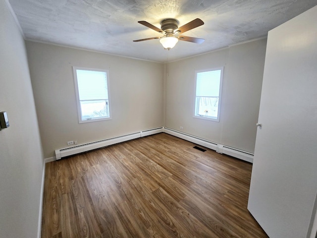 unfurnished room featuring ceiling fan, a textured ceiling, a baseboard radiator, wood finished floors, and ornamental molding