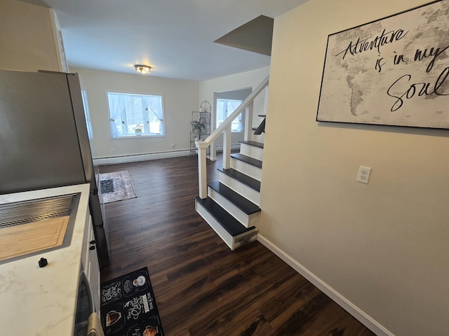 stairs featuring baseboards, baseboard heating, and wood finished floors