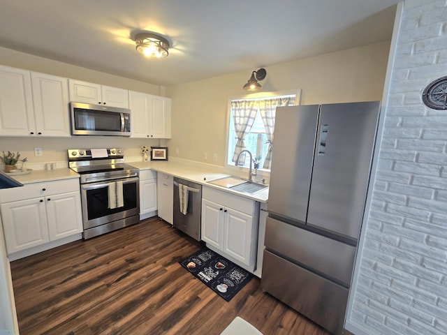 kitchen with stainless steel appliances, light countertops, dark wood-type flooring, white cabinets, and a sink