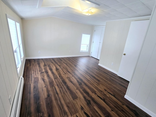 unfurnished bedroom with a baseboard radiator, dark wood finished floors, and baseboards