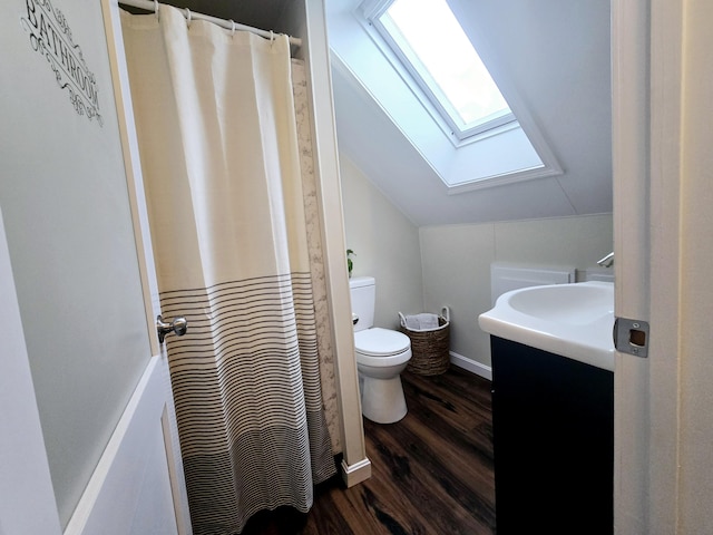 full bathroom with toilet, lofted ceiling with skylight, wood finished floors, curtained shower, and vanity