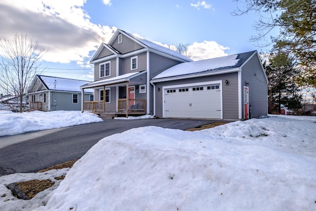 traditional-style home featuring an attached garage, aphalt driveway, and a porch