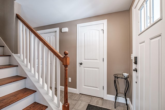 foyer entrance featuring baseboards and stairs