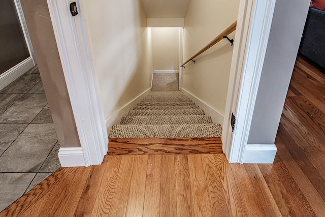 stairs featuring wood finished floors and baseboards